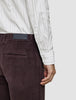 En person som har på seg en Elevated Shirt Slim Light Grey Striped, som er stappet inn i mørkebrune corduroybukser.