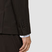 Nærbilde av en brun Motion Blazer Regular Cognac-erme med fire mansjettknapper og en hvit skjorteerme under.