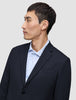 En mann i en Motion Blazer Regular i fargen Midnight Blue og en lyseblå stripete skjorte.