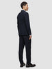 En mann i en midnattsblå Motion Blazer Regular og bukser med 360°-stretch ser til siden.