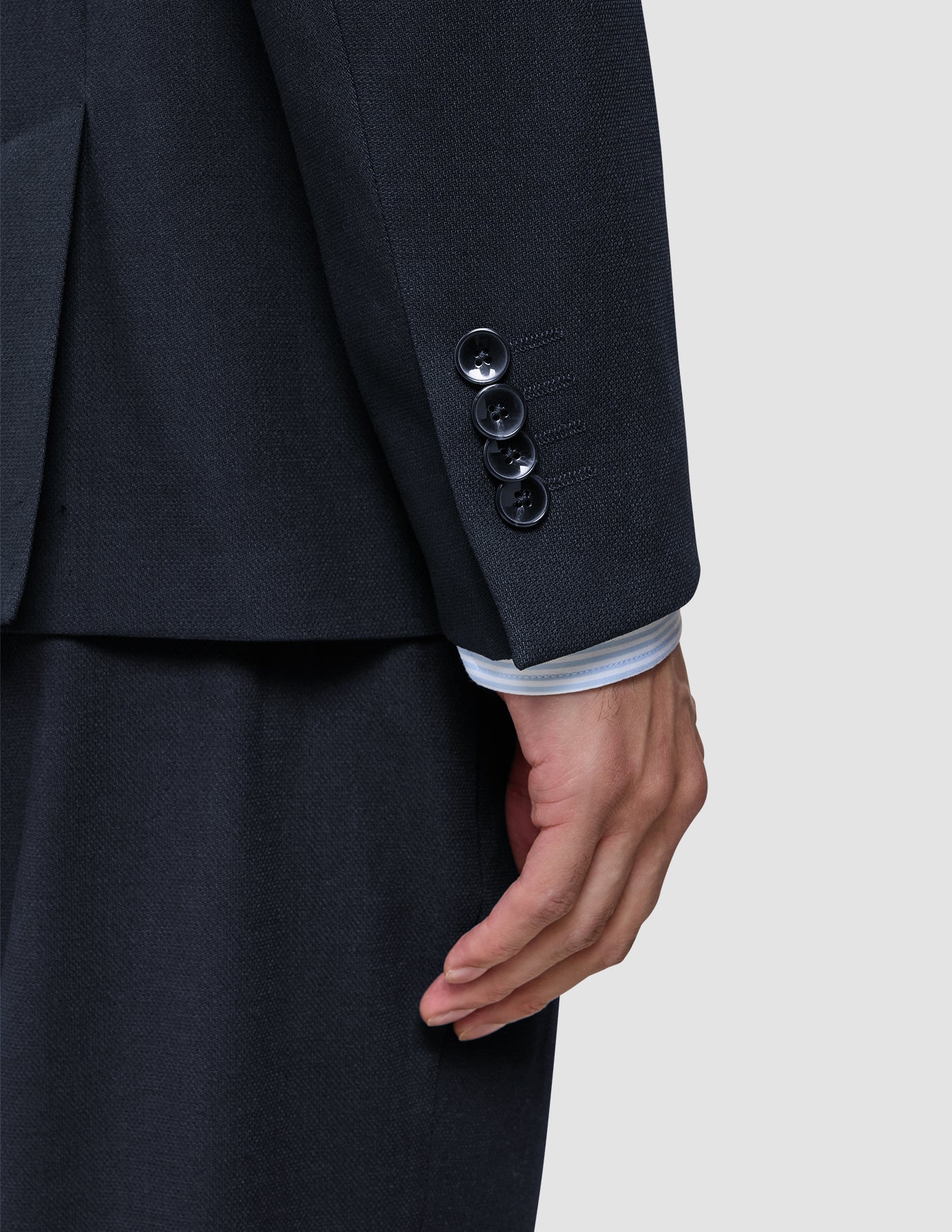 Nærbilde av en erme på en Motion Blazer Regular i fargen Midnight Blue, som viser fire mansjettknapper og en skjorteerme under.