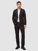 En mann kledd i en Motion Blazer Slim Cognac, hvit skjorte, svart belte og svarte dressko.