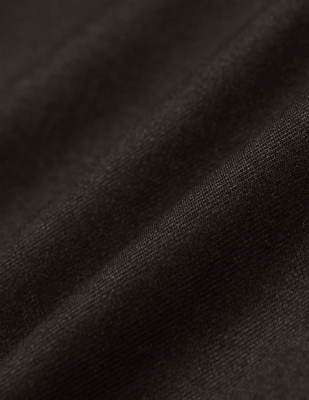Nærbilde av myke folder i mørkebrunt 360°-stretchstoff på Motion Suit Pants Regular Cognac.