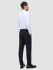En mann i hvit skjorte og en Midnight Blue Motion Suit Pants Regular-bukse står med ryggen til kameraet.