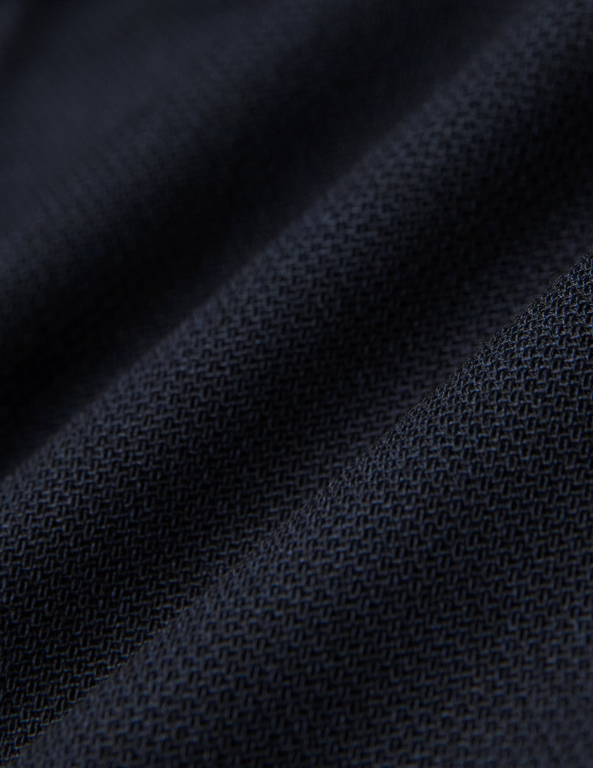 Nærbilde av brettede Motion Suit-bukser i Regular-modell, fargen Midnight Blue, med mørkeblått strukturert stoff og 360°-stretch.