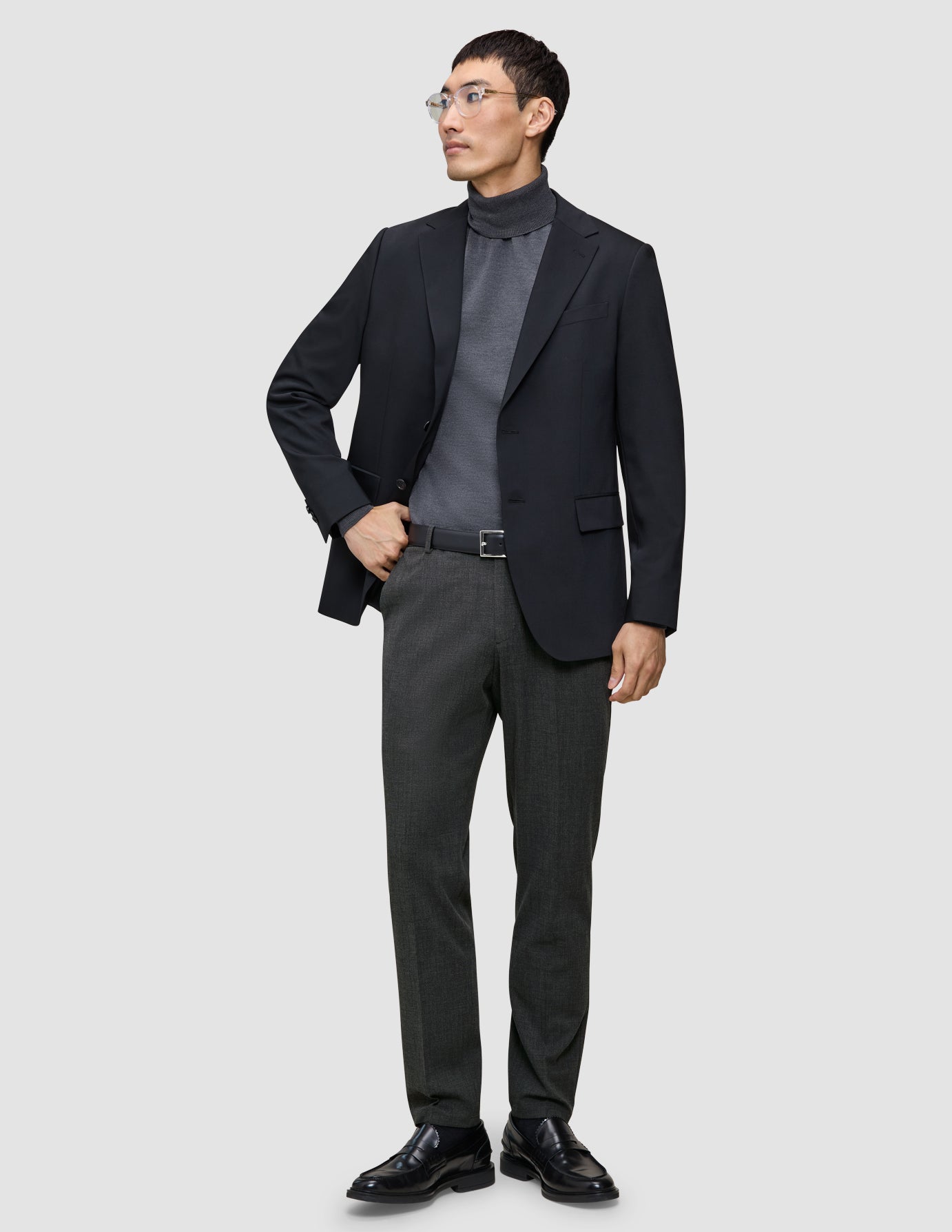 En mann i svart blazer og grå turtleneck har på seg Motion Suit Pants Regular Pepper Grey med skandinavisk design.