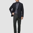 En mann i svart blazer og grå turtleneck har på seg Motion Suit Pants Regular Pepper Grey med skandinavisk design.