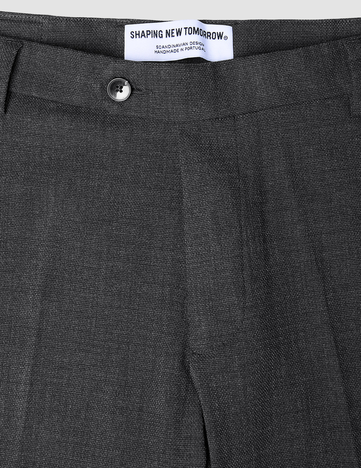 Motion Suit-bukse i Regular-passform, Pepper Grey, i klassisk skandinavisk design med knapp midt foran og hvit merkelapp.