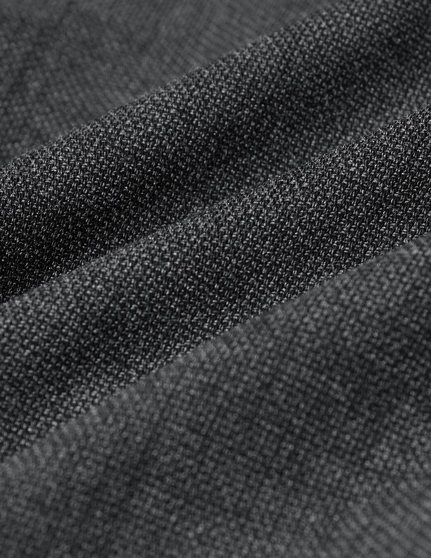 Nærbilde av Motion Suit-bukser i fargen pepper grey i Regular-passform, med et strukturert, strikk-lignende vev og 360°-stretch.