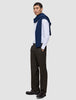 En mann i en hvit skjorte med smale striper, en marineblå genser og Motion Suit Pants Relaxed Cognac med 360°-stretch.