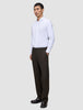 En mann i en hvit skjorte og Relaxed Cognac Motion-dressbukser med avslappet passform.