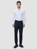 En mann i en hvit skjorte med knapper, midnattsblå Motion Suit Pants Slim og brune loafers.