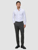 En mann kledd i en hvit skjorte med knapper, Motion Suit Pants Slim Pepper Grey og svarte loafers.