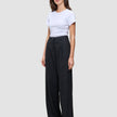 En kvinne iført en hvit T-skjorte og svarte Serene Pants Wide Black med høy midje.