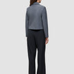 En person sett bakfra, kledd i en grå blazer og svarte Serene Pants Wide Black.