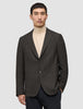 En mann som har på seg en Timeless Wool Blazer Slim i mørkebrun rutemønster over en beige turtleneck-genser.