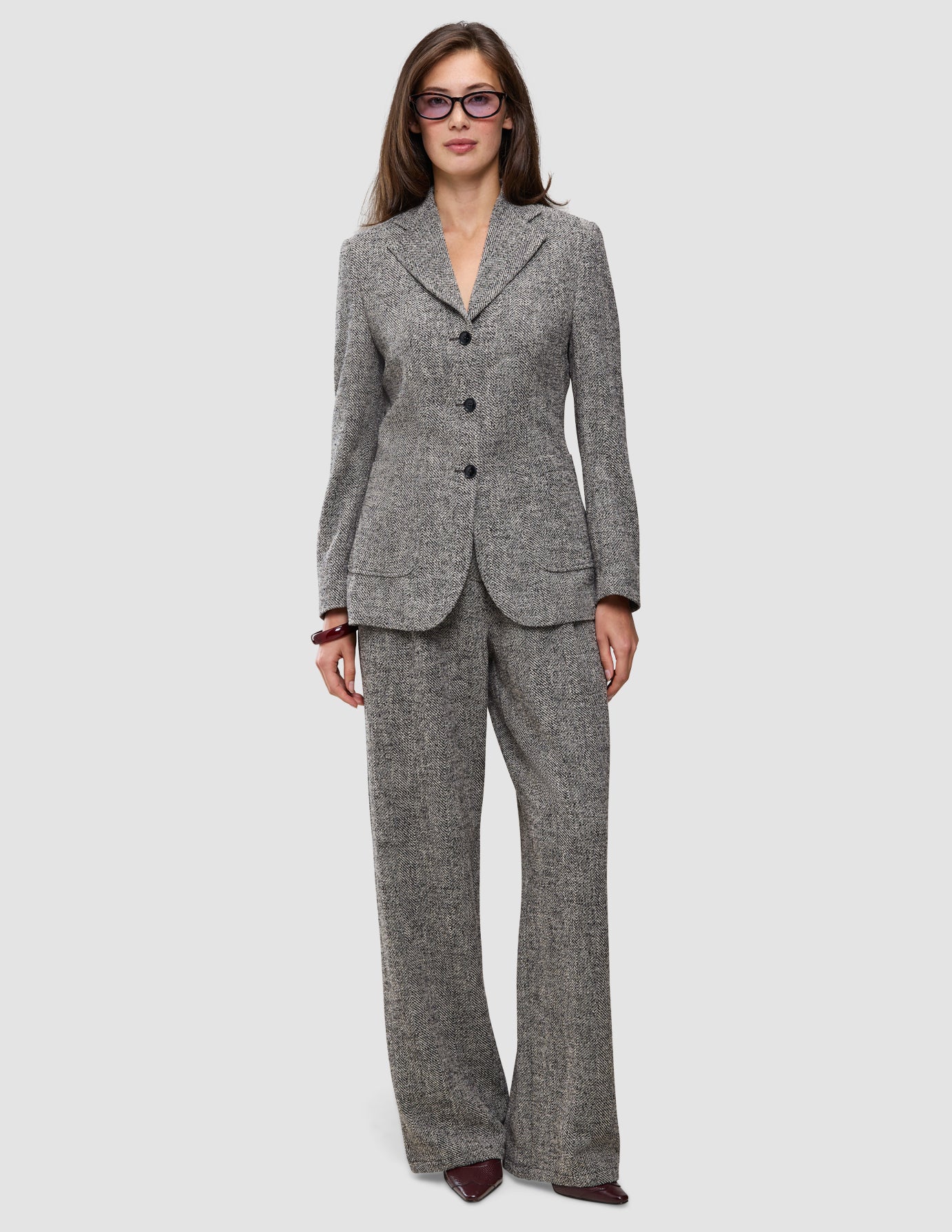 En kvinne i en grå blazer med fiskebensmønster og matchende Women Ashryn Pants Wide Domino Herringbone.
