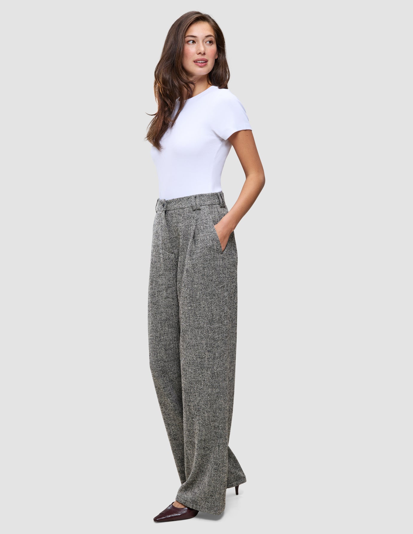 En kvinne i en hvit T-skjorte og Women Ashryn Pants Wide Domino Herringbone-bukser.