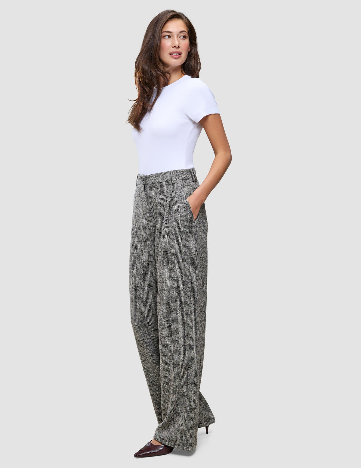 En kvinne i en hvit T-skjorte og Women Ashryn Pants Wide Domino Herringbone-bukser.