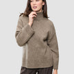 En kvinne som har på seg en Women Chunky Soft Wool Knit Turtleneck Taupe Melange-genser.