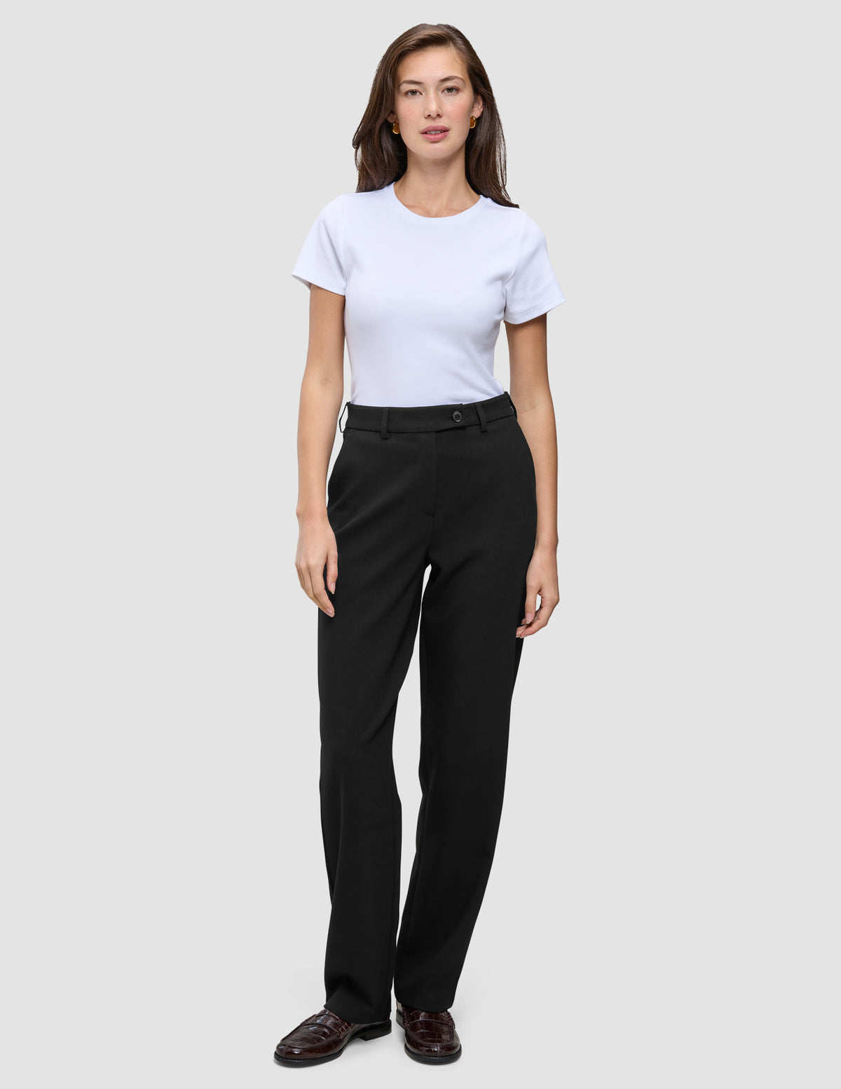 En kvinne iført en hvit T-skjorte og Women GO2 Pants Straight Black med rette ben.
