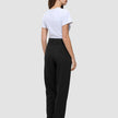 En kvinne sett bakfra, kledd i en hvit T-skjorte og svarte Women GO2 Pants Straight med rett snitt.
