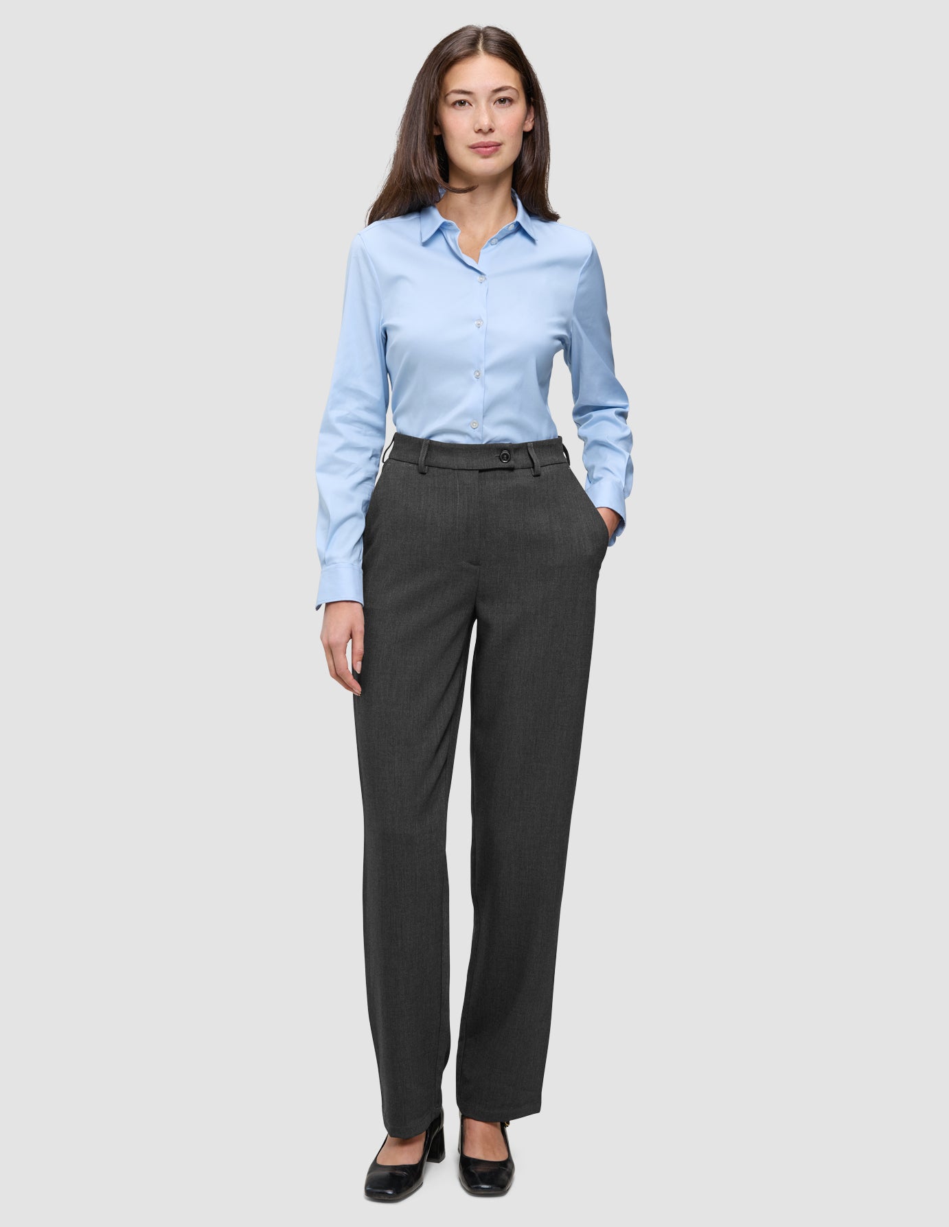En kvinne iført en lyseblå skjorte med knapper og Women GO2 Pants Straight Dark Grey Melange med rett snitt.