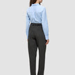 En person som har på seg en lyseblå skjorte med knapper, stappet inn i Women GO2 Pants Straight Dark Grey Melange, med et svart belte.