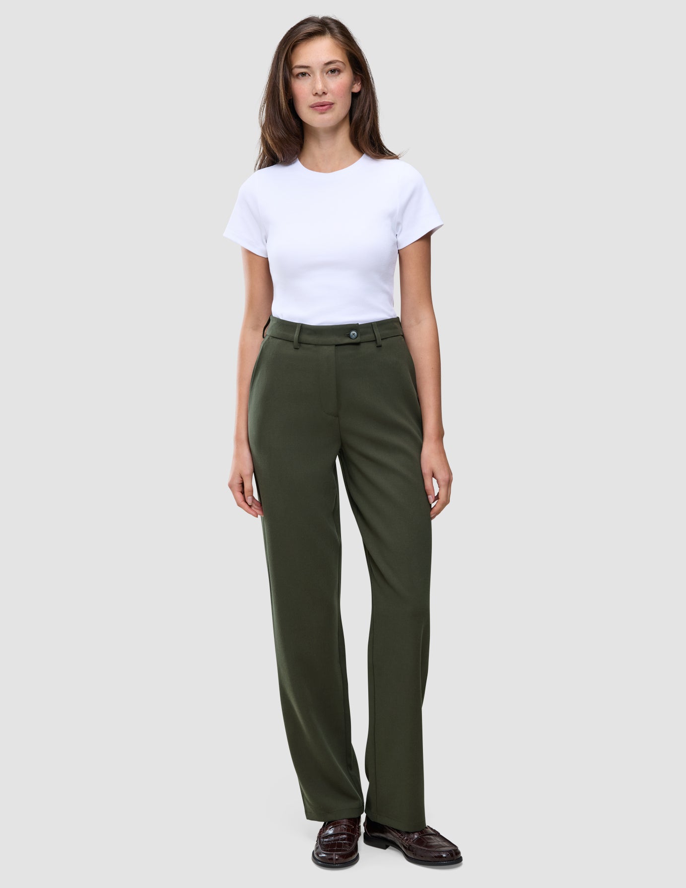 En kvinne har på seg en hvit T-skjorte og Women GO2 Pants Straight Dusty Olive med rett snitt.