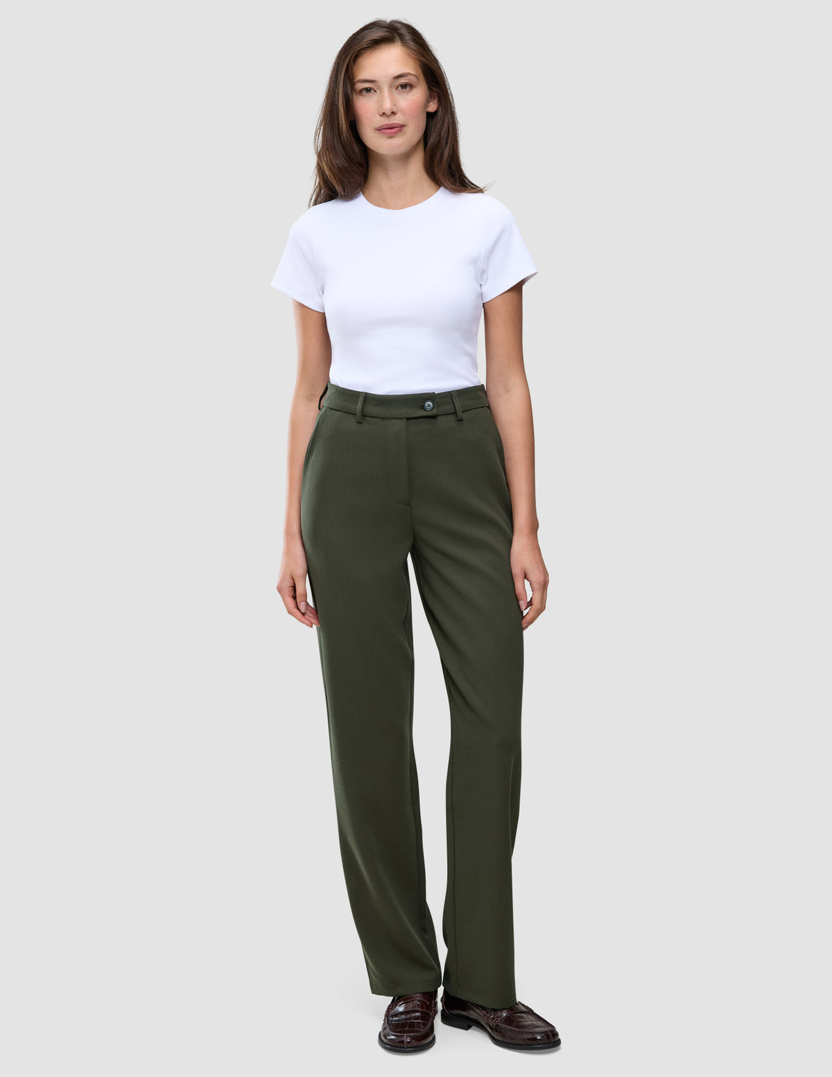 En kvinne har på seg en hvit T-skjorte og Women GO2 Pants Straight Dusty Olive med rett snitt.