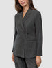En kvinne iført en Women Nara Blazer Fitted Black Check – en skreddersydd blazer i kullgrått med dobbeltspent knappestolpe og rutemønster.