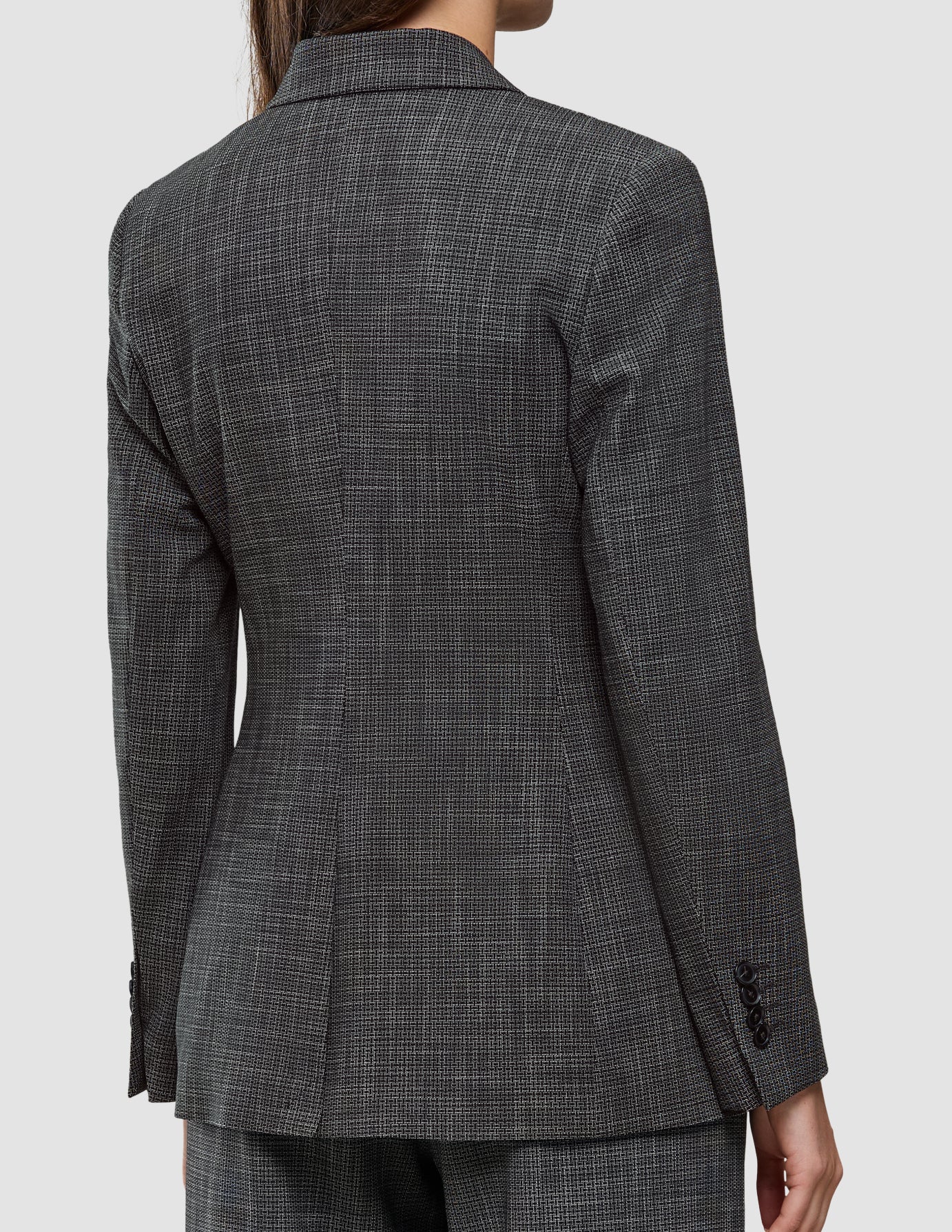 Baksiden av en Women Nara Blazer Fitted Black Check med et svart-hvitt mikrorutemønster.