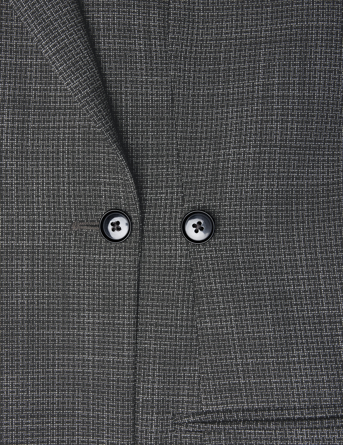 Nærbilde av Women Nara Blazer Fitted Black Check, en kullgrå blazer med et diskret hvitt rutemønster og to svarte knapper.