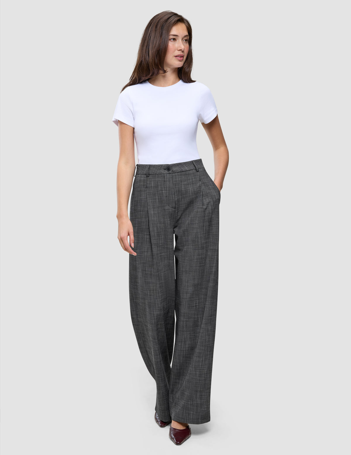En kvinne iført en hvit T-skjorte og Women Nara Pants Wide Black Check med 360°-stretch.