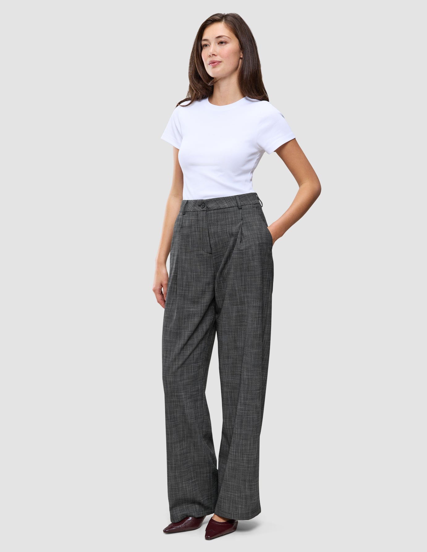 En kvinne iført en hvit T-skjorte og Women Nara Pants Wide Black Check med mørkegrått rutemønster.