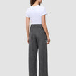 En person sett bakfra, kledd i en hvit T-skjorte og Women Nara Pants Wide Black Check med et diskret rutemønster.