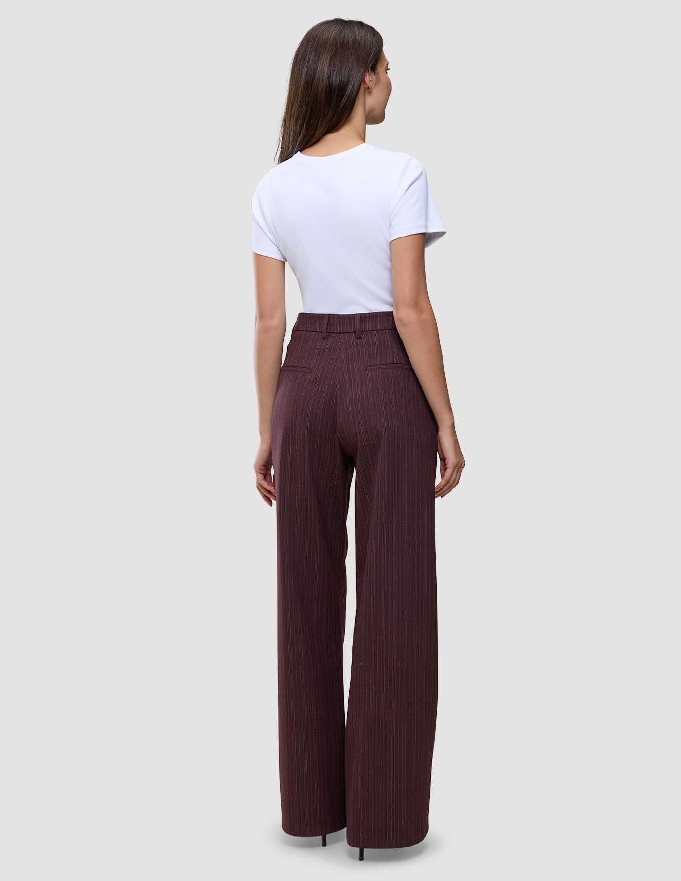 En kvinne sett bakfra har på seg en hvit T-skjorte og buksene Women Serene Pants Wide Berry Pinstripe med vide ben.