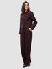 En kvinne kledd i en minimalistisk Women Serene Short Jacket Berry Pinstripe og matchende bukser med vide ben.